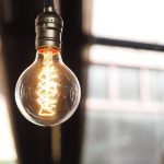 Gowing modern light bulb on bright background